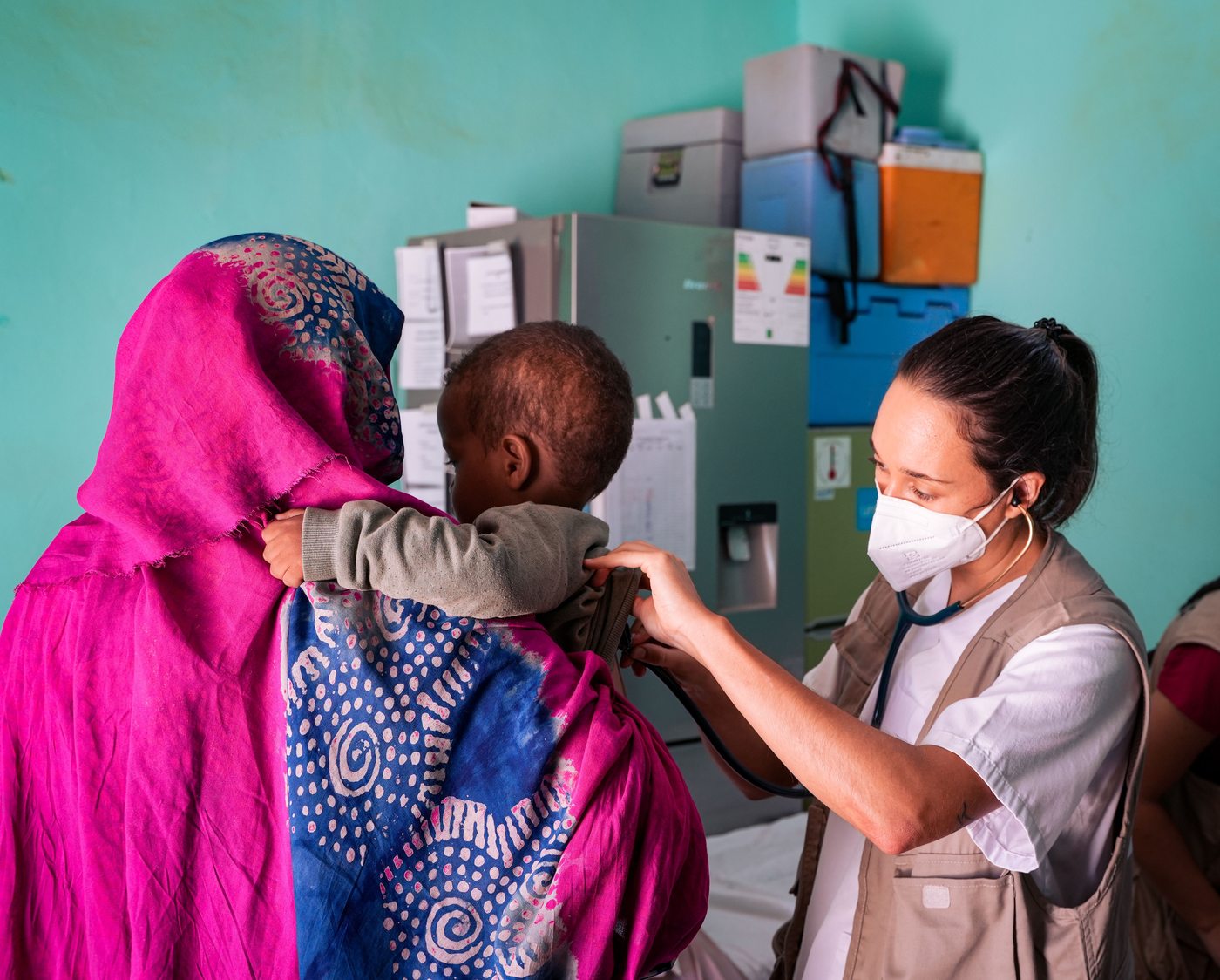 A health worker examining a child at a health facility
