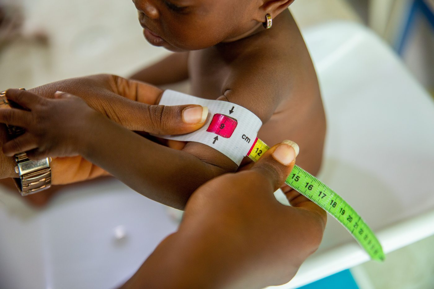 Health worker measuring a child's mid-upper arm circumference