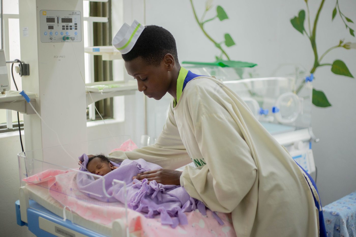 A nurse caring for a newborn in a neonatal ward